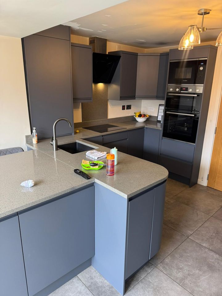 Anthracite handleless kitchen with curved peninsula and pendant lights