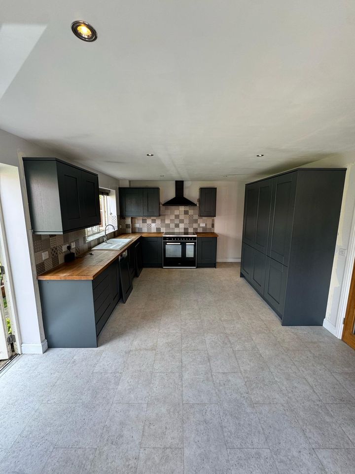 Charcoal shaker open-plan kitchen with oak worktops and tall larder units