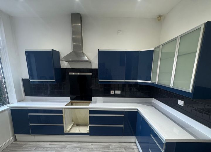Navy high-gloss handleless kitchen with white worktops