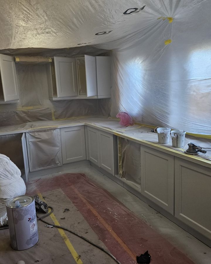 A sprayer preparing base units inside a fully tented kitchen